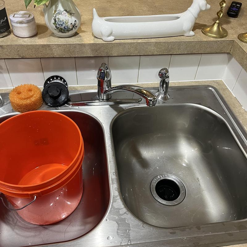 Kitchen sink and drain with orange bucket and sponge