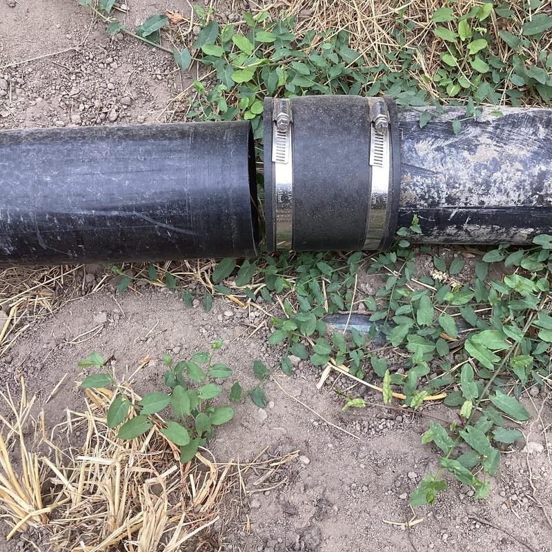 Water service line rubber coupling with clamps outdoors
