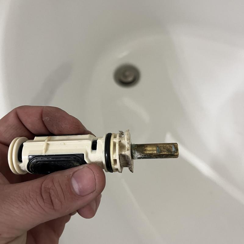 Moen Posi temp cartridge held over bathtub drain
