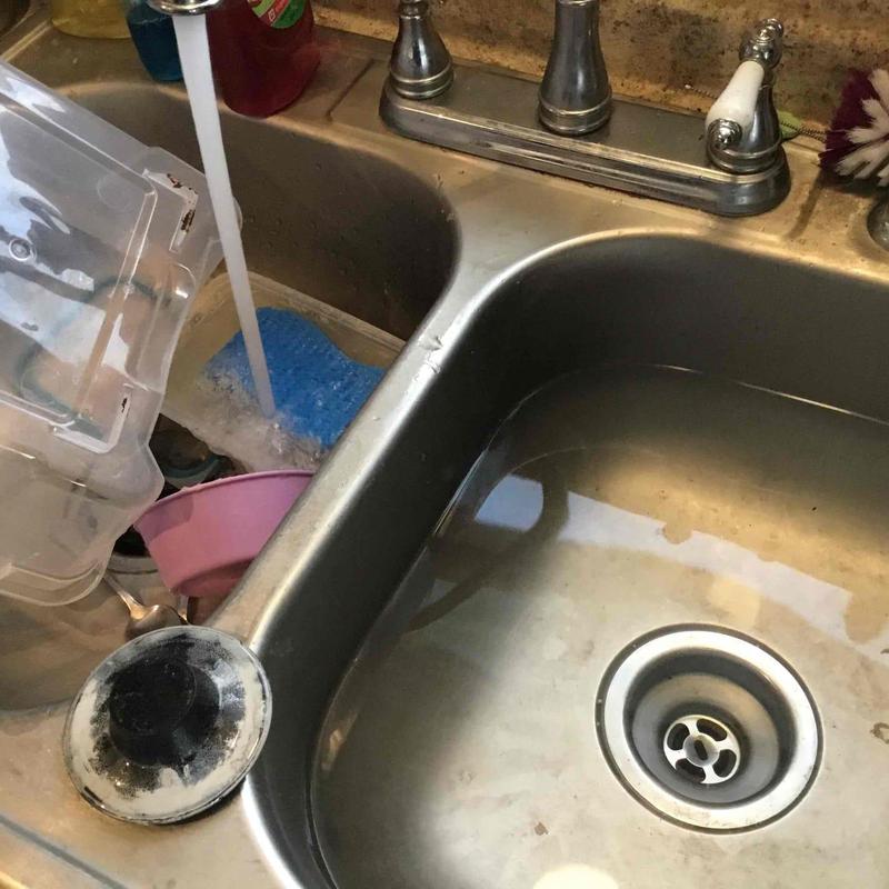Kitchen sink drain clog clearing with running water
