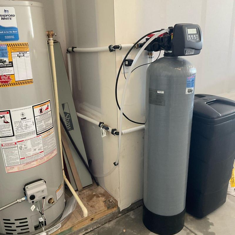 Water softener system installation in garage next to heater