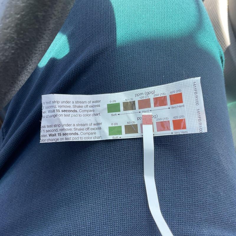 Water hardness test strip showing 120 ppm hardness level