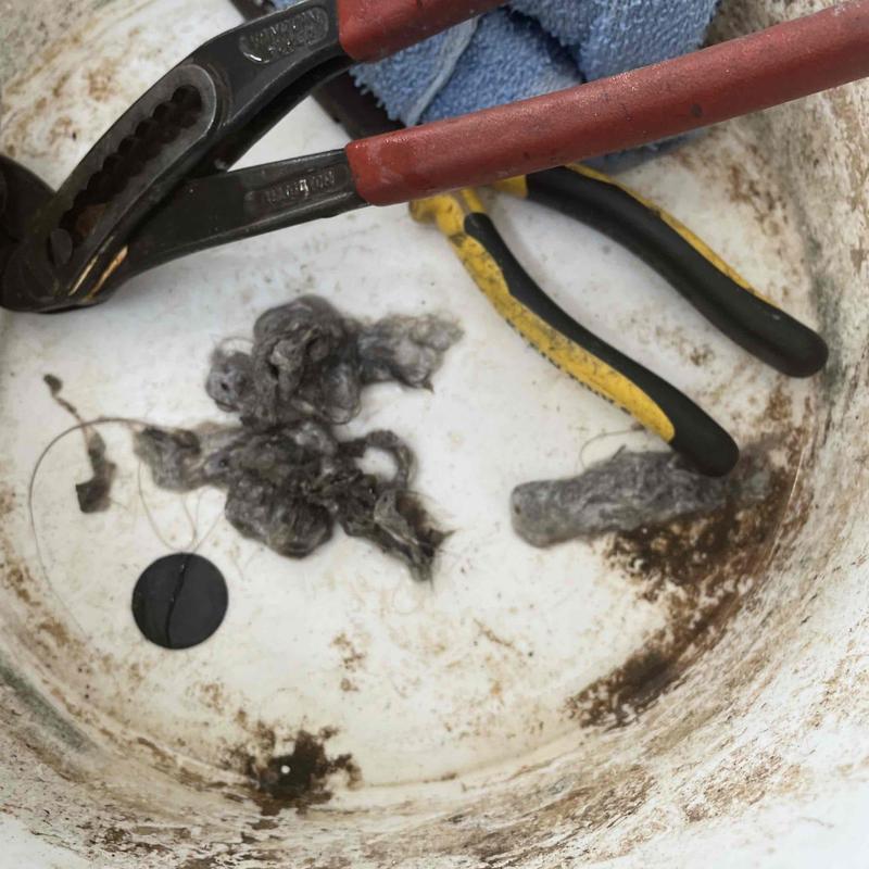 Bathtub drain clog with removed hair and tools