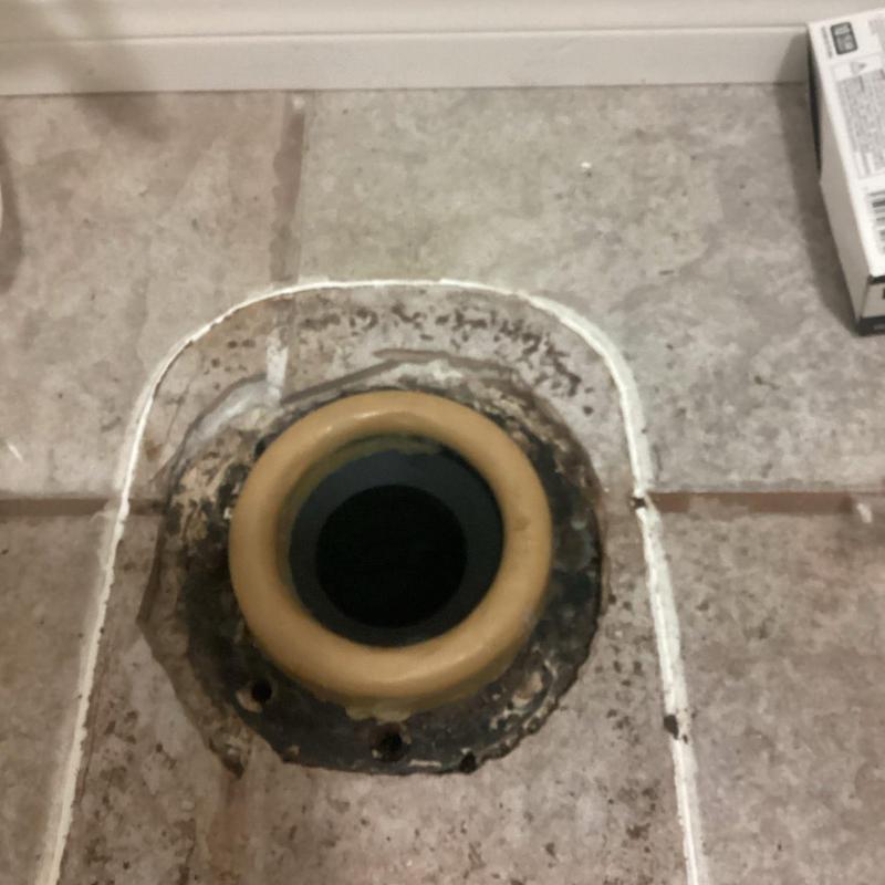 Toilet flange with new wax ring on tile floor