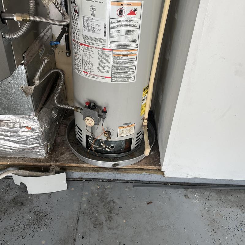 Gas water heater with exposed wiring and disconnected panel