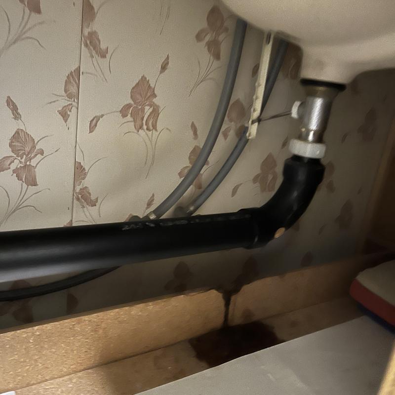 Under sink drain pipe with water stain below