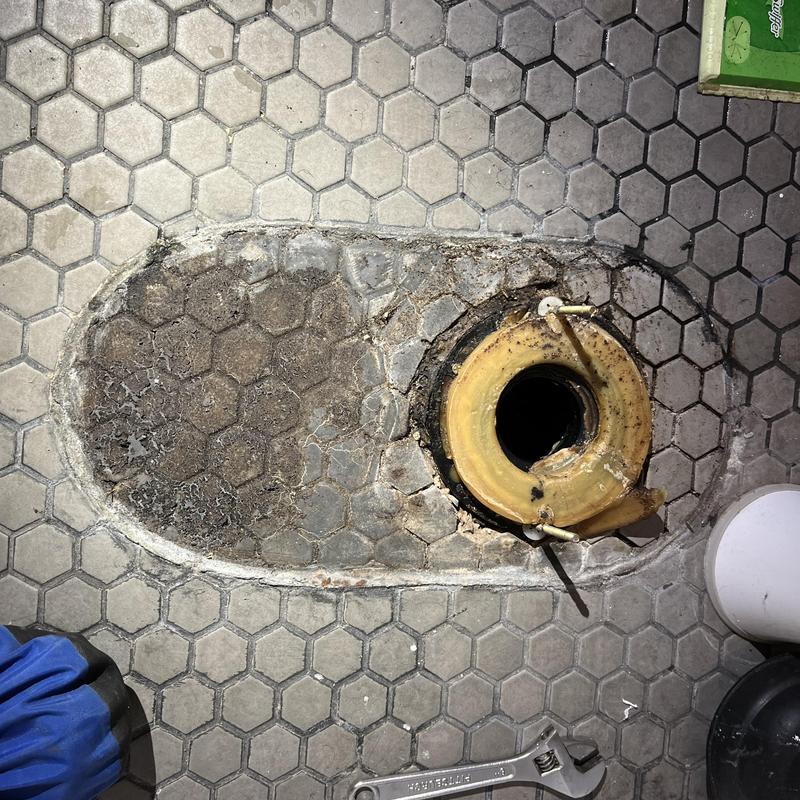 Toilet flange on hex tile floor with repair work