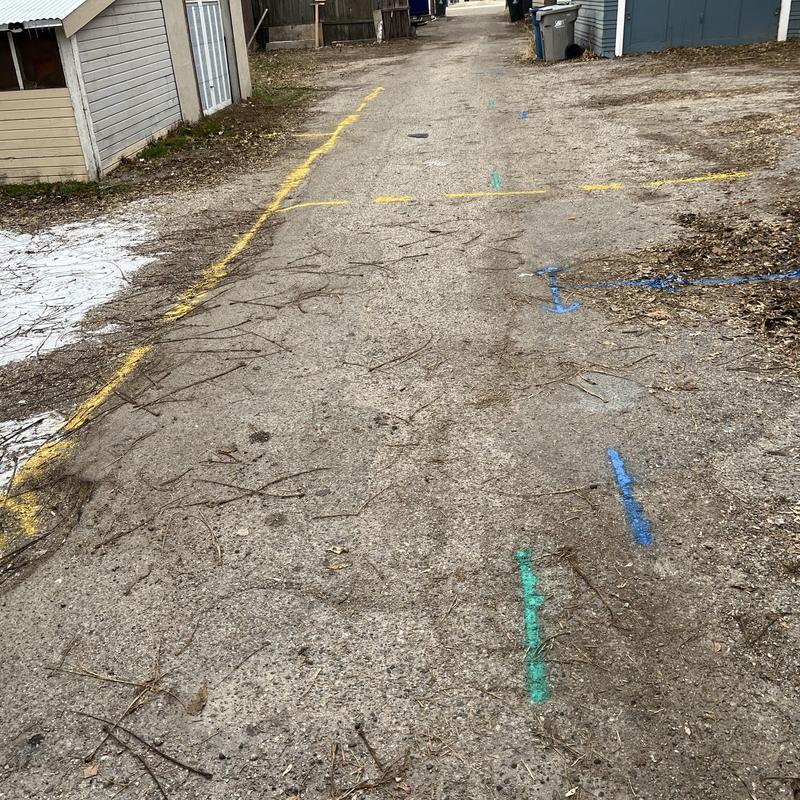 Concrete pipe burst excavation markings on dirt alley