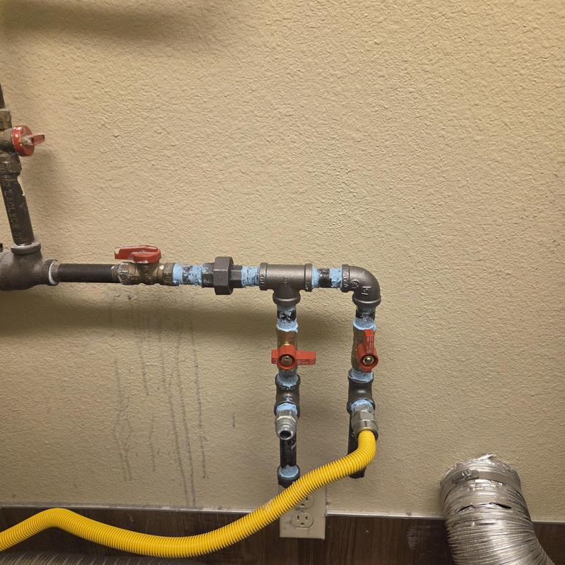 Gas line with valves and yellow corrugated tubing for dryer