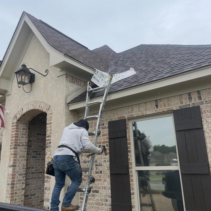 Roof shingles with tarp over leak and ladder setup