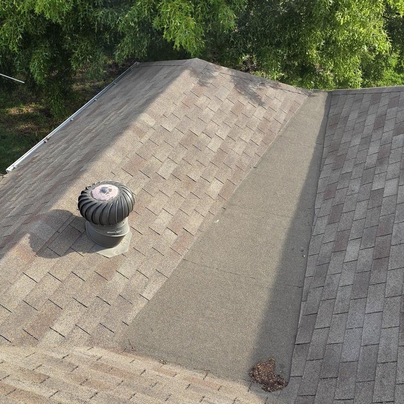 Asphalt shingle roof with hail damage and vent turbine