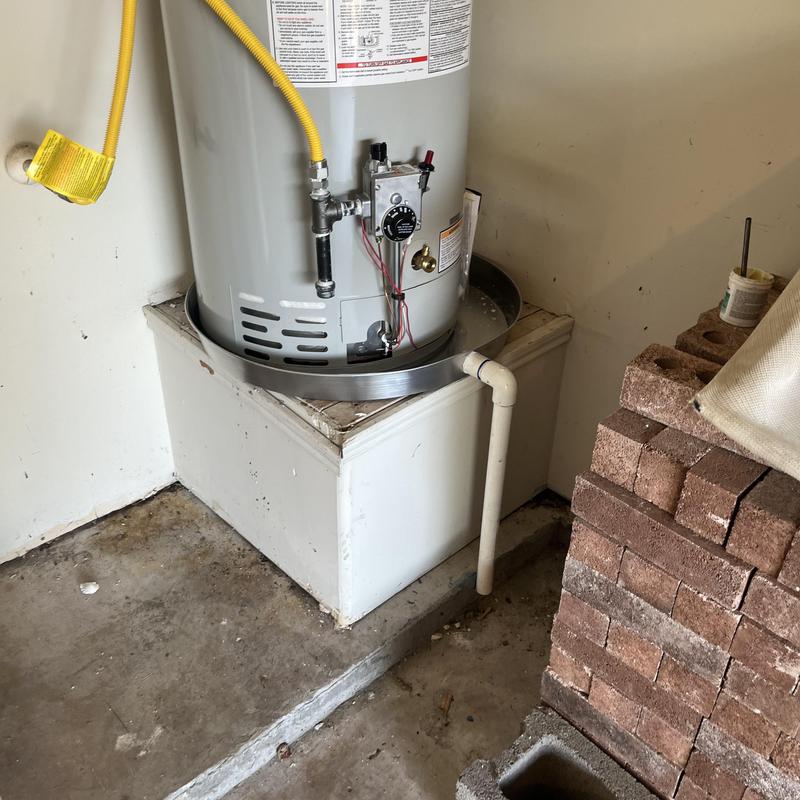 50 gallon gas water heater on platform with piping