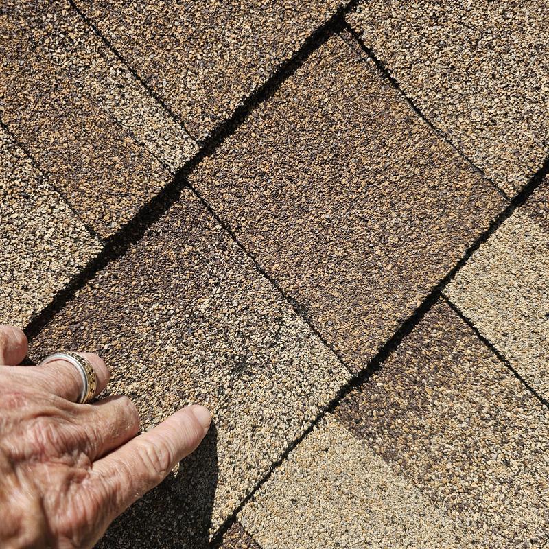 Roof shingles with hail damage close-up inspection