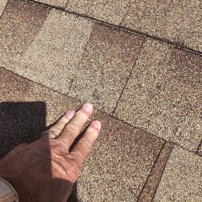 Asphalt roof shingles with hail damage close-up