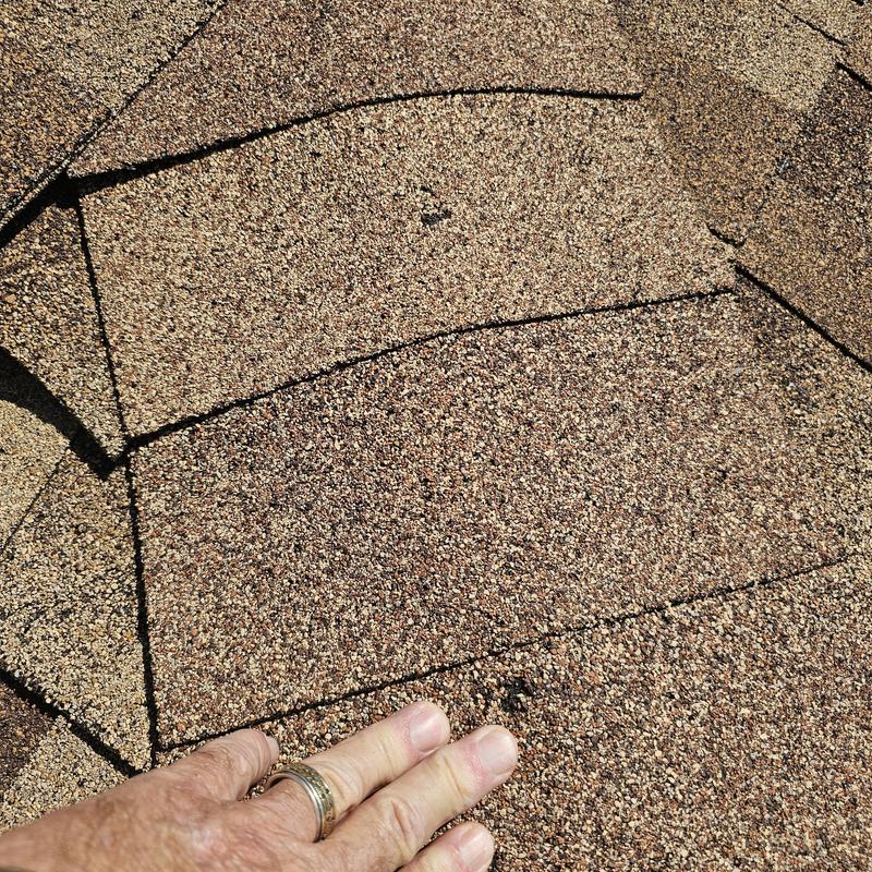 Asphalt roof shingles with hail damage close-up