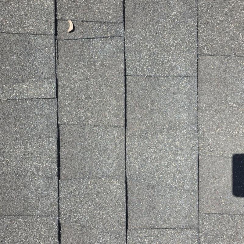 Roof shingles close-up showing repaired seams and flashing area