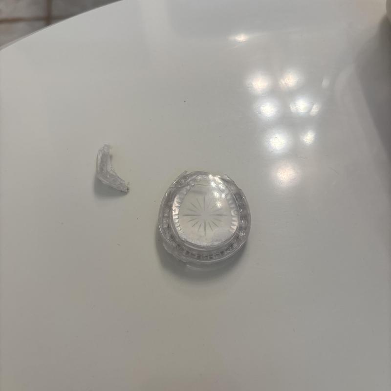Clear plastic shower valve handle broken piece on table Clear plastic shower valve handle broken piece on table