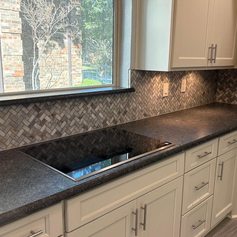 Quartz countertop with leathered finish and herringbone backsplash