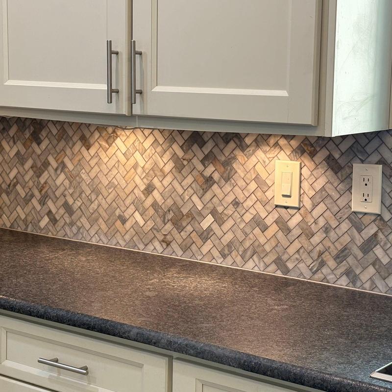 Quartz countertop with leathered finish and herringbone backsplash
