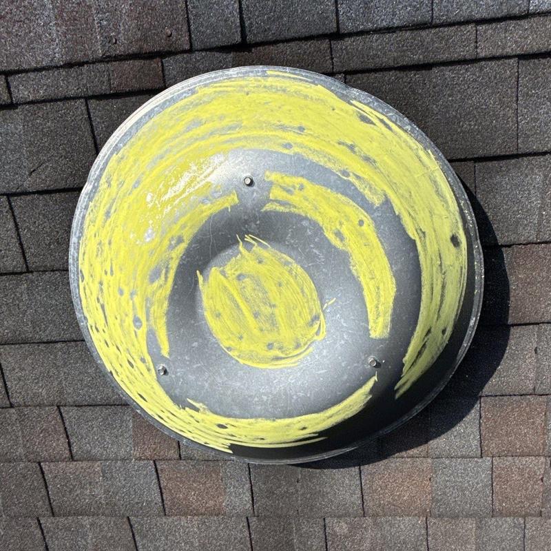 Roof vent with yellow hail damage marking on shingles