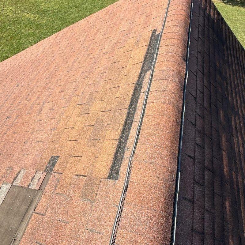 Asphalt shingle roof with hail damage near ridge vent