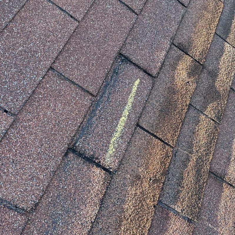 Asphalt shingles with hail damage marked in yellow