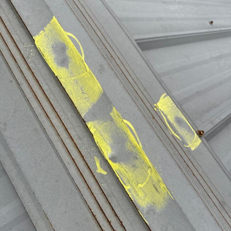 Metal roof hail damage marked with yellow paint