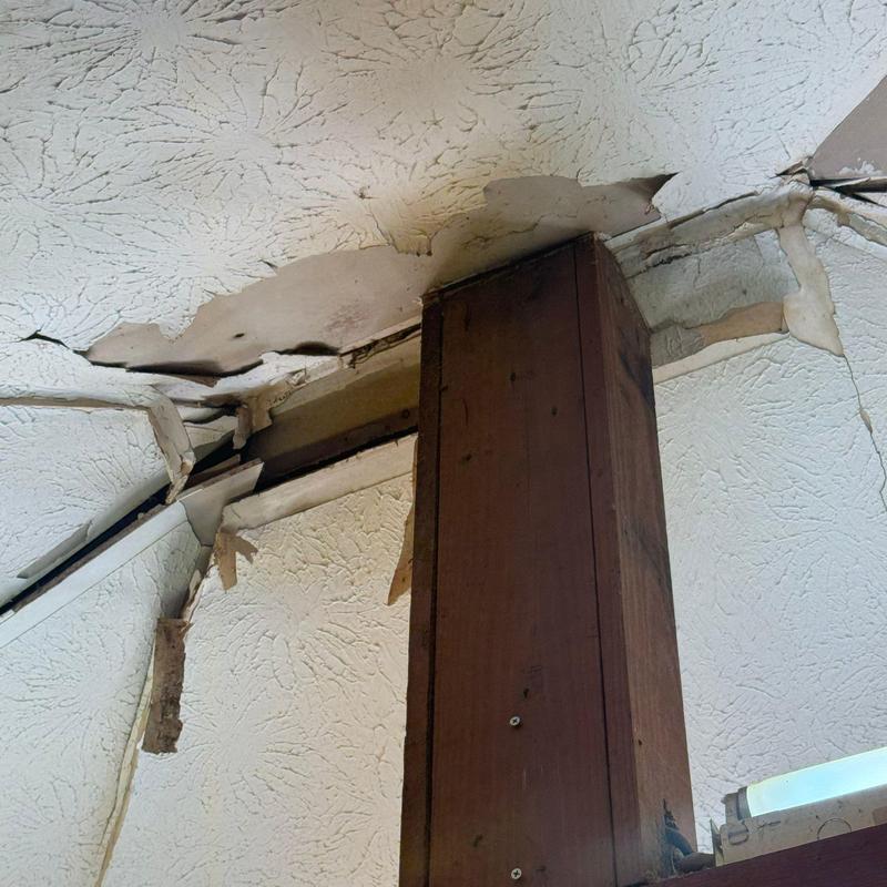 Ceiling drywall with water damage and cracks