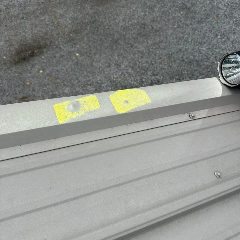 Metal roofing panel with marked hail damage dents