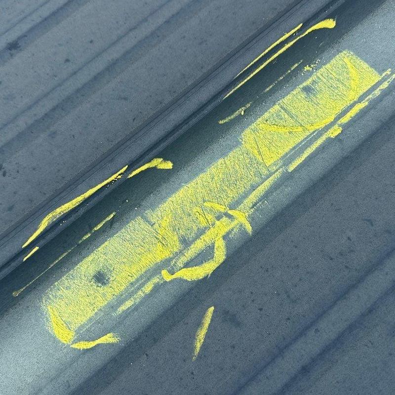Metal roof panel with marked hail damage
