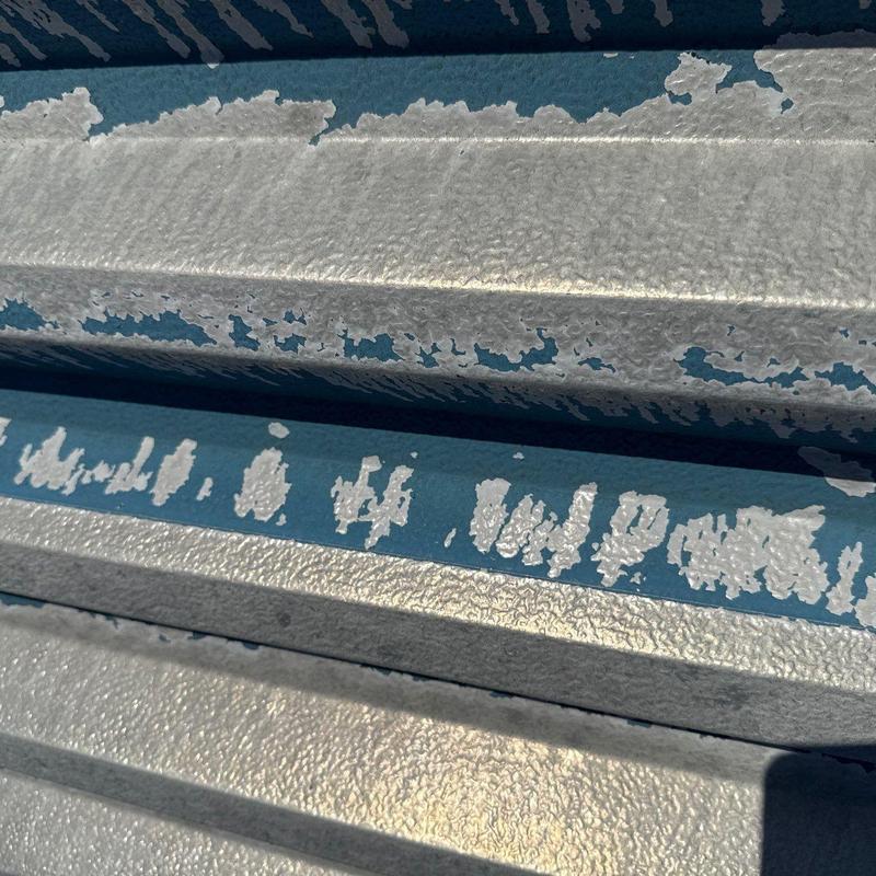 Metal roofing panels with peeling paint and surface wear