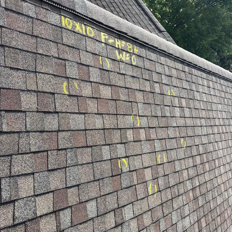 Asphalt shingles with yellow markings for hail damage