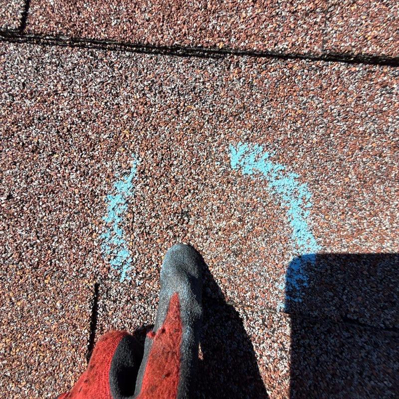 Roof shingles with hail damage marked in blue chalk