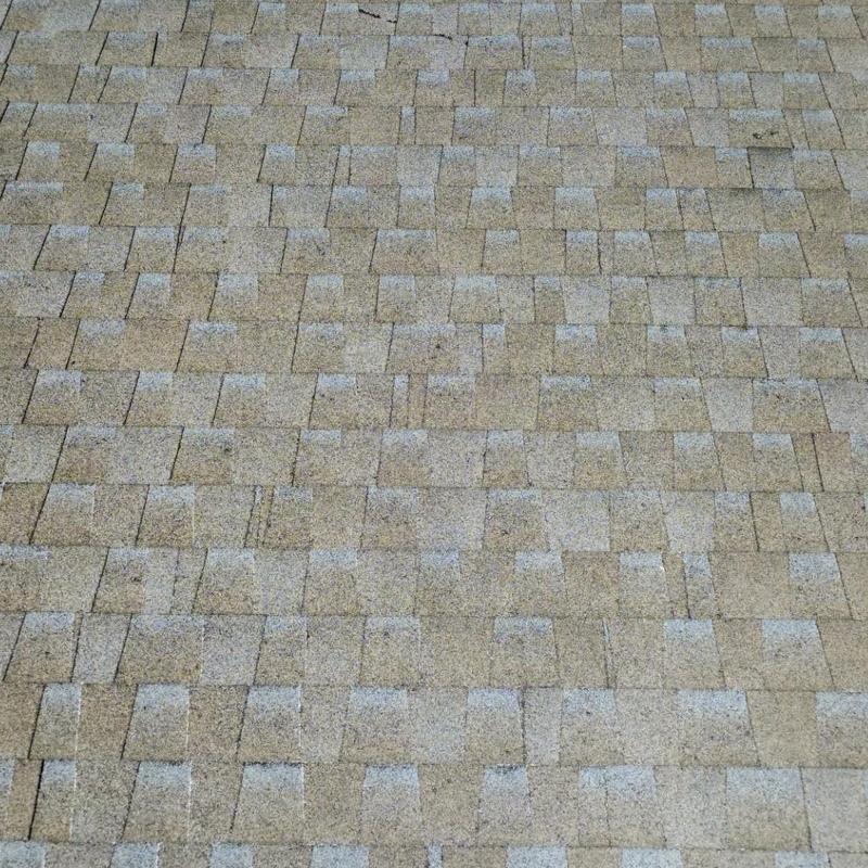Asphalt roof shingles with visible wear and damage