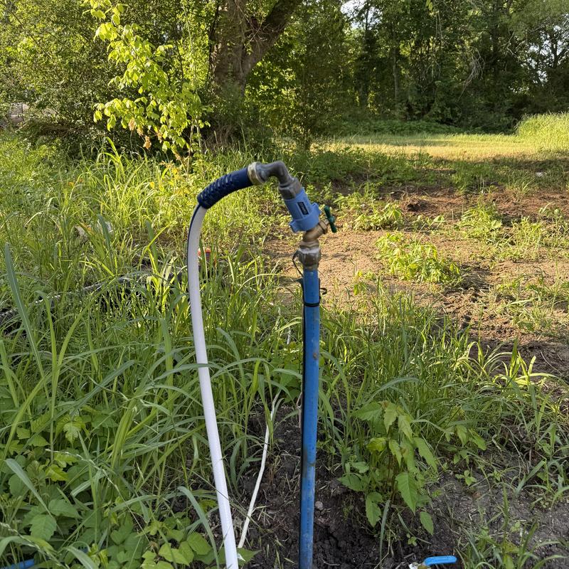 Heavy-duty hose bib with attached garden hose outdoors