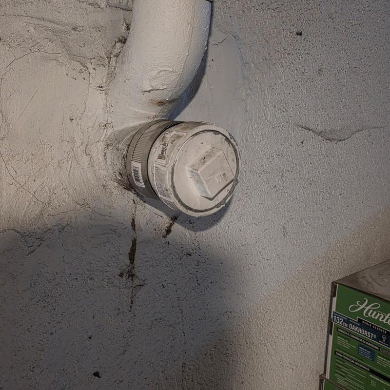 Cleanout pipe cap replaced on wall plumbing system