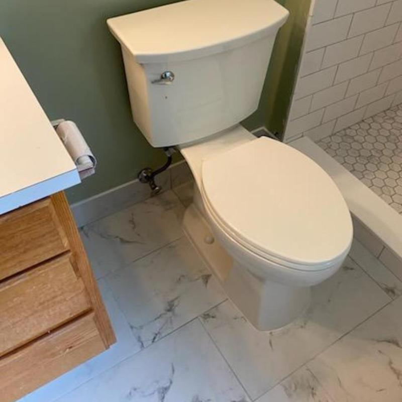 Toilet installation with new shower plumbing in bathroom