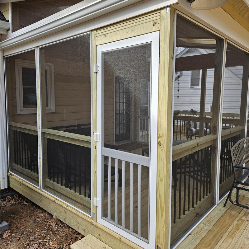 Screened porch enclosure with wooden frame and door