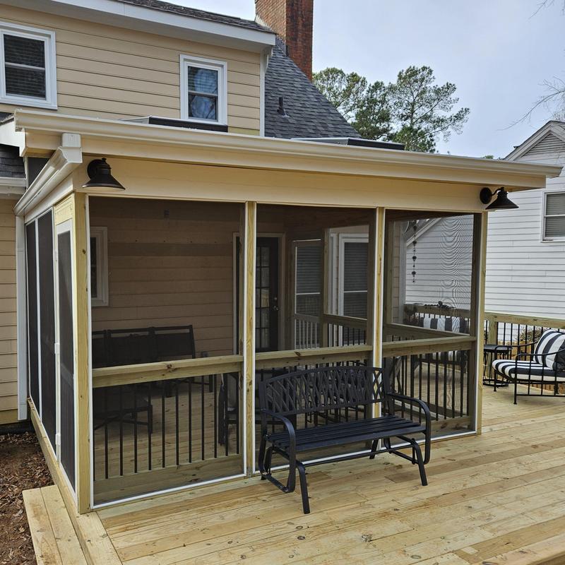 Screened porch addition on wooden deck in backyard