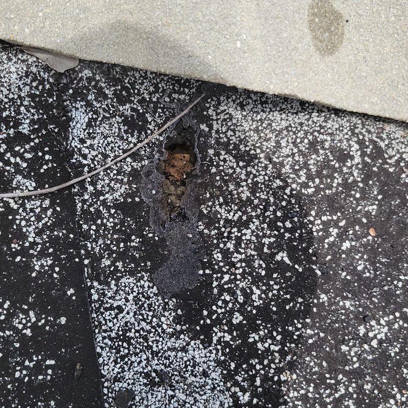 Built-up roof membrane with visible puncture damage