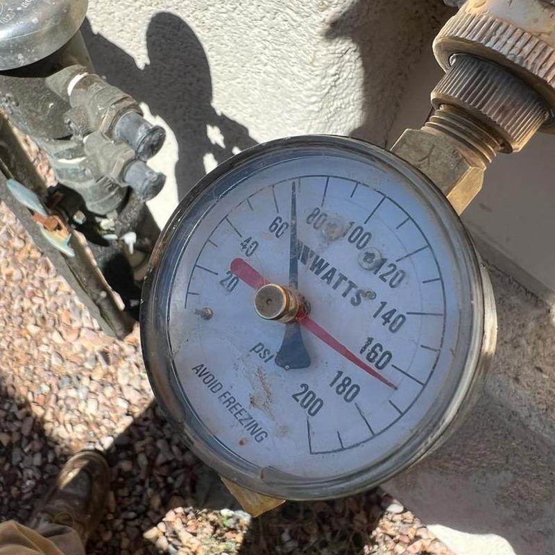 Pressure gauge on water supply valve showing 68 PSI
