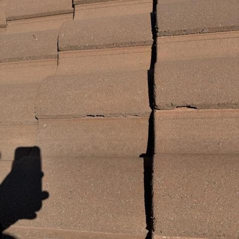 Concrete roof tiles with visible cracks and damage