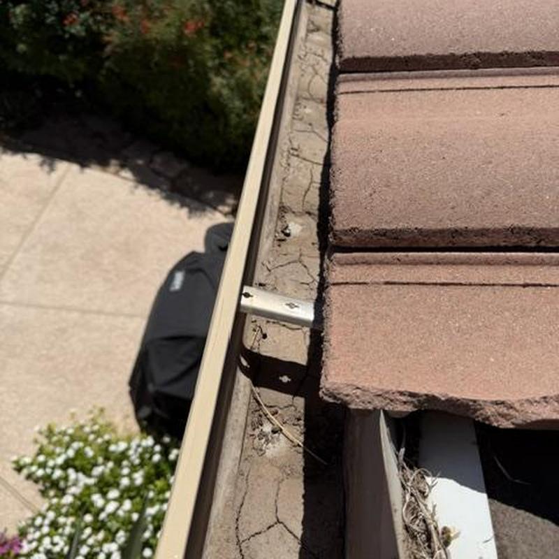 Concrete tile roof edge with cracked underlayment and loose tiles