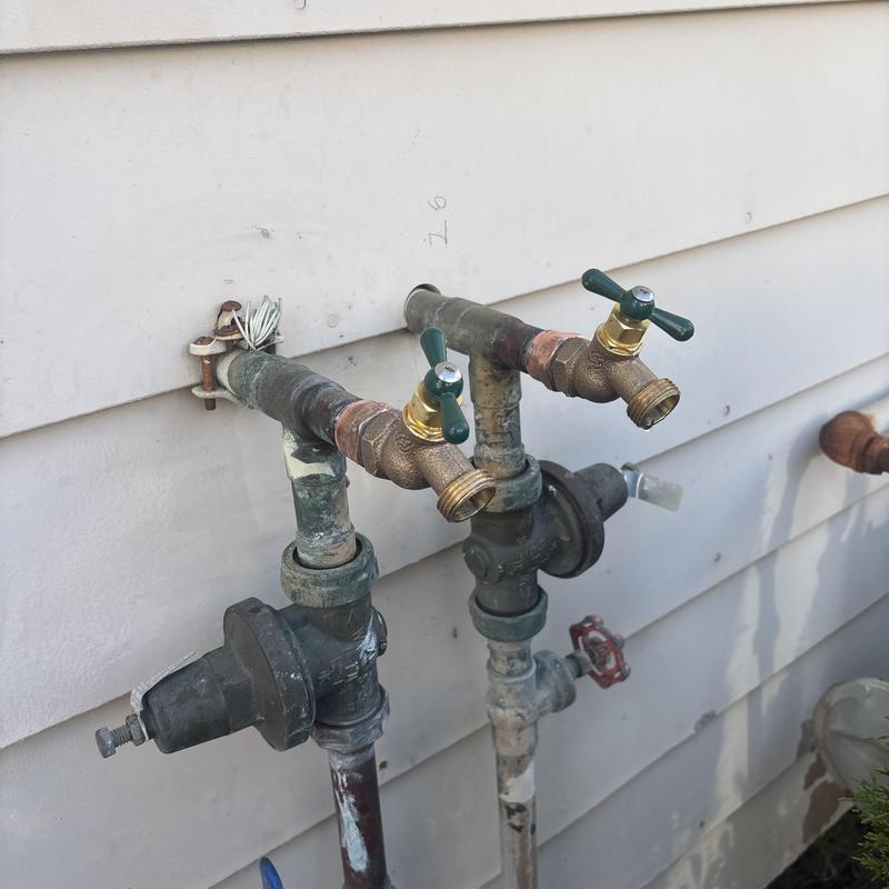 Hose bib spigots with new valve handles on exterior wall Hose bib spigots with new valve handles on exterior wall