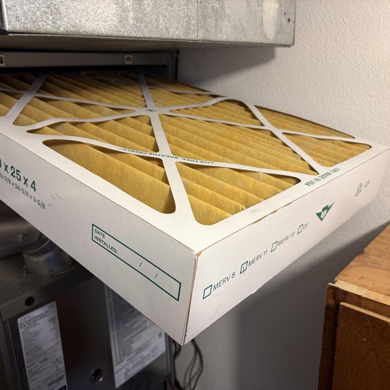 HVAC air filter being installed in system slot
