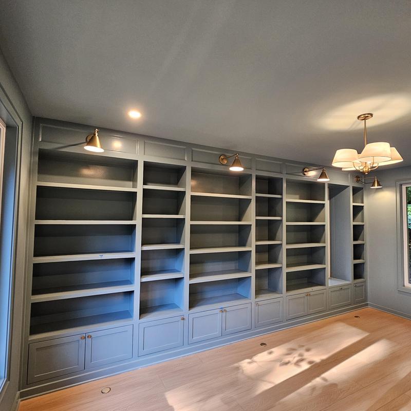 Built-in gray bookshelves with overhead lighting installation