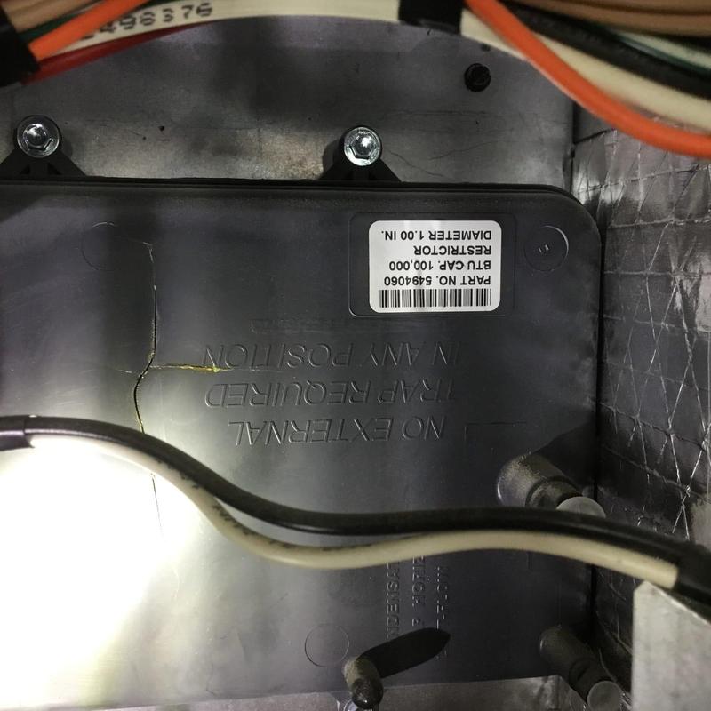 Furnace restrictor with wiring and bolts visible