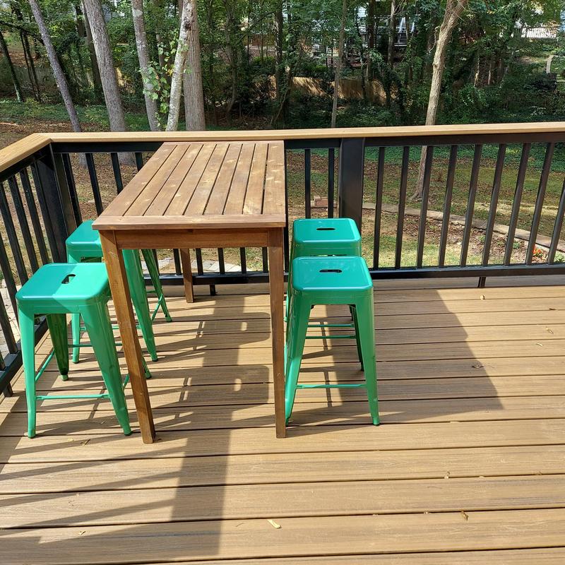 Composite deck flooring with green metal stools and wood table