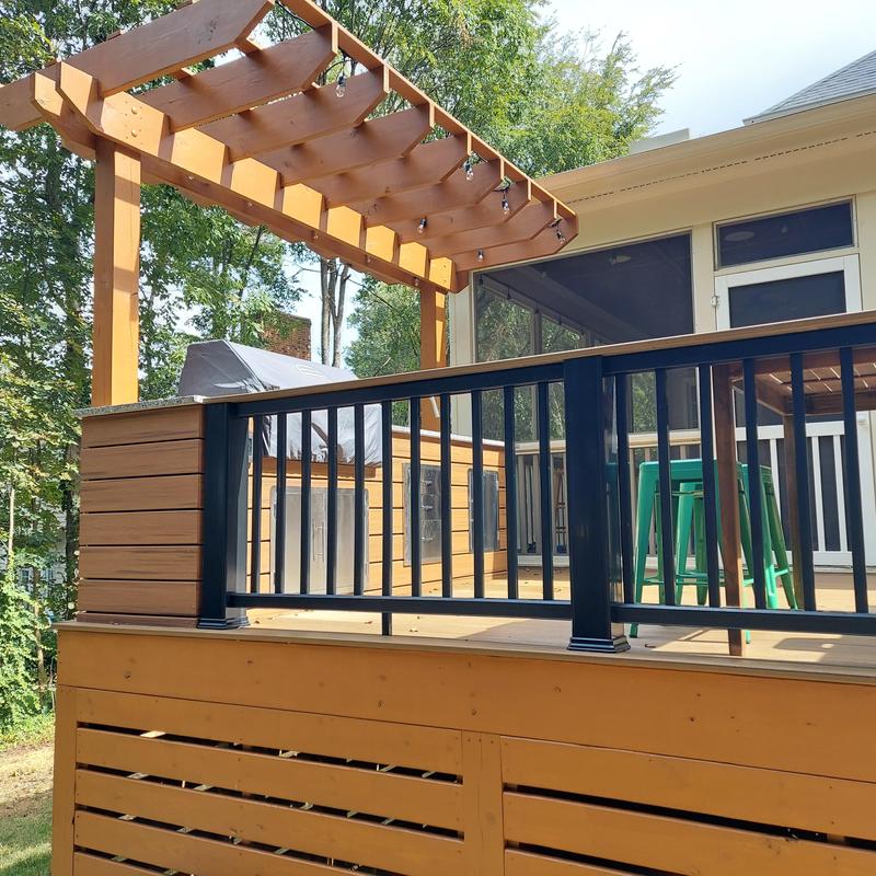 Wooden deck with black metal railing and pergola