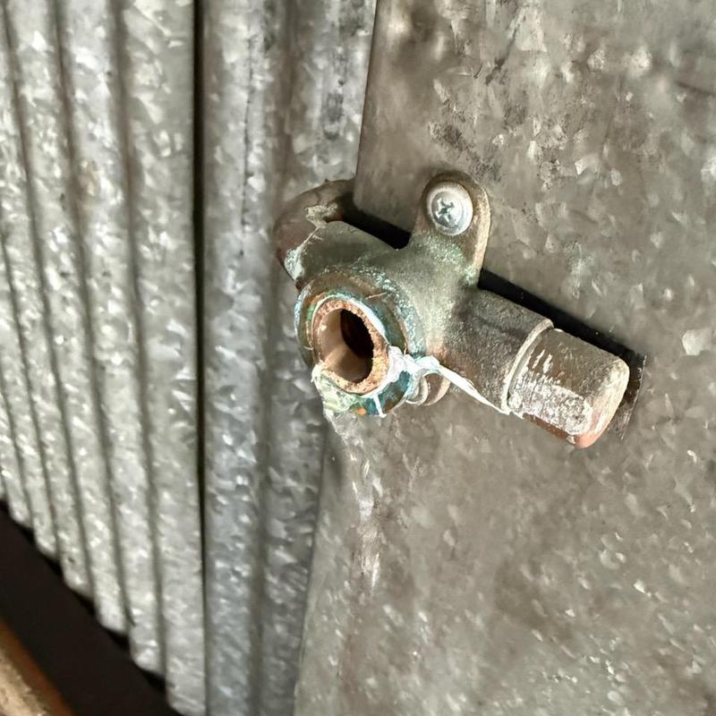 Corroded outdoor hose bib on metal siding wall Corroded outdoor hose bib on metal siding wall